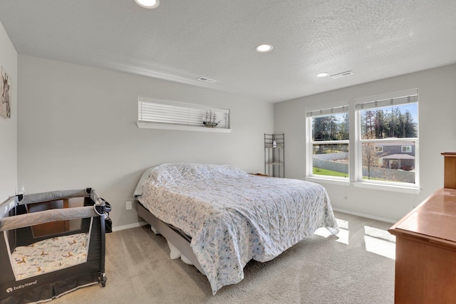 carpeted bedroom featuring baseboards, recessed lighting, and a textured ceiling