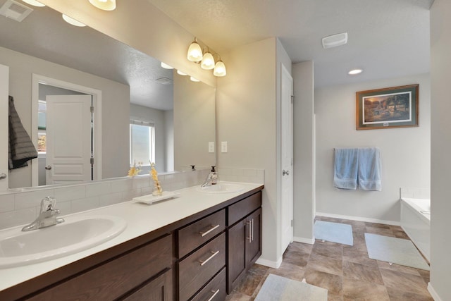 7407 E Beverly Ave, Spokane Valley, WA 99212 - full bathroom featuring double vanity, a garden tub, baseboards, backsplash, and recessed lighting