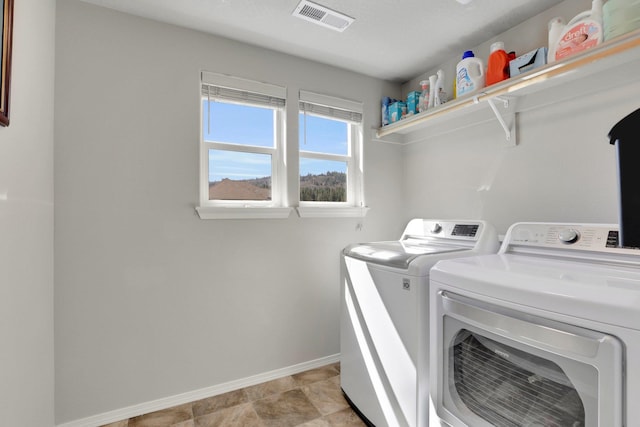 washroom with baseboards and washer and clothes dryer