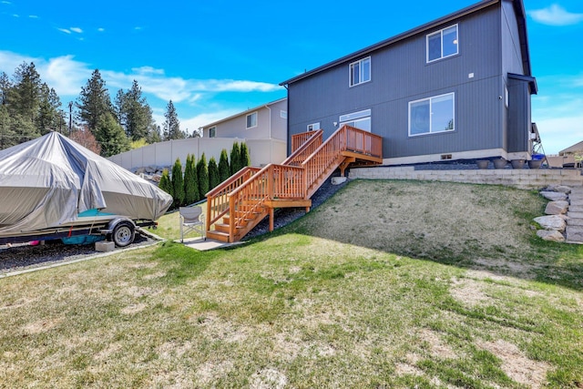 back of house featuring a lawn and stairs