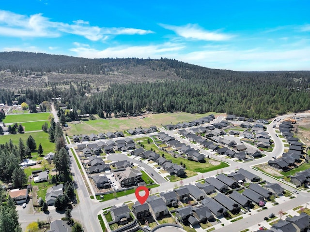 aerial view of property's location with a heavily wooded area and nearby suburban area