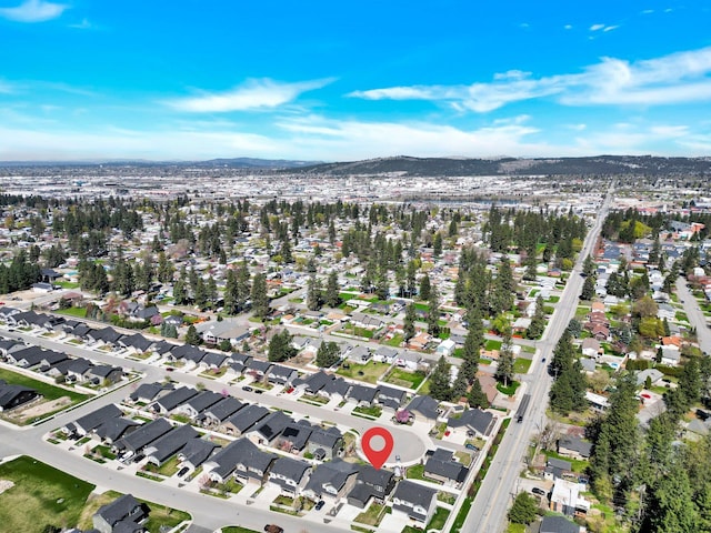 aerial view of property's location featuring a mountain backdrop and nearby suburban area