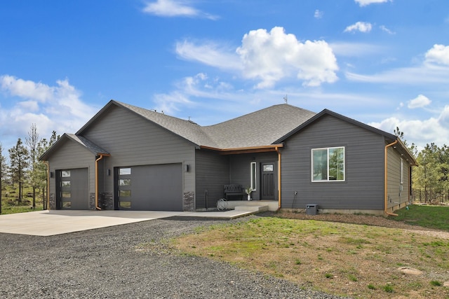 single story home featuring an attached garage, roof with shingles, and driveway