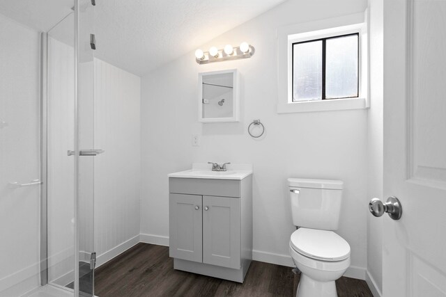 219 F St, Cheney, WA 99004 - bathroom featuring wood finished floors, a stall shower, toilet, vanity, and baseboards