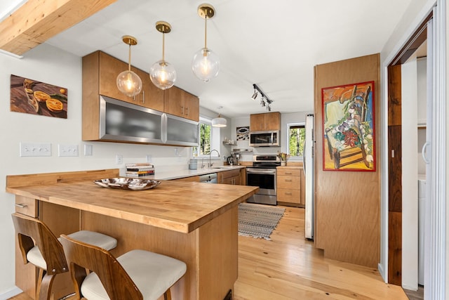 4167 Grouse Creek Rd, Loon Lake, WA 99148 - kitchen featuring a peninsula, wooden counters, stainless steel appliances, light wood finished floors, and a sink