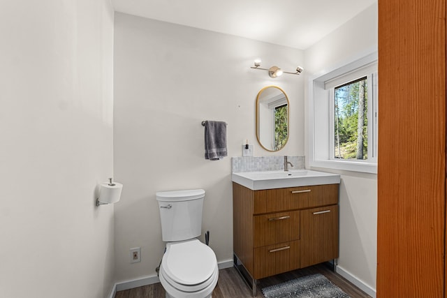4167 Grouse Creek Rd, Loon Lake, WA 99148 - half bath with vanity, toilet, wood finished floors, baseboards, and backsplash