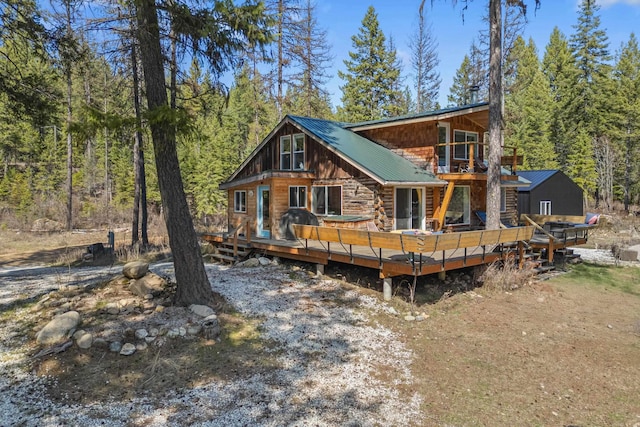 4167 Grouse Creek Rd, Loon Lake, WA 99148 - rear view of house featuring a view of trees, a deck, and metal roof