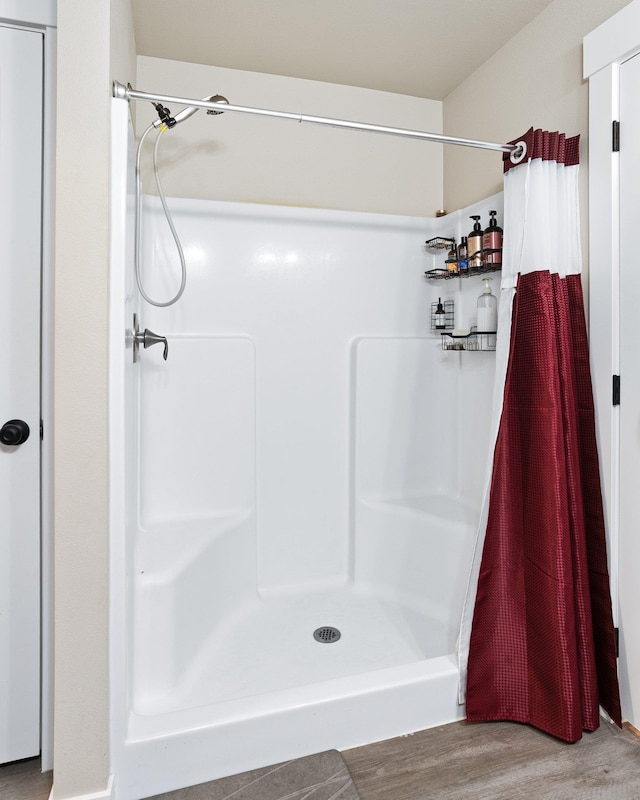 full bathroom with wood finished floors and a stall shower