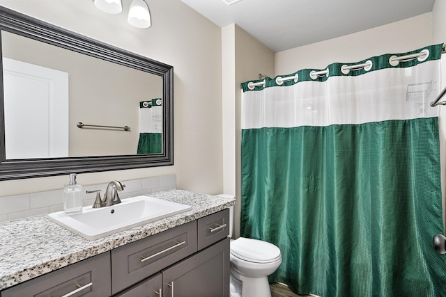 full bathroom featuring toilet, vanity, and curtained shower