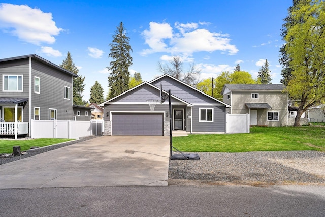 view of front of home featuring driveway, stone siding, fence, a garage, and a front yard