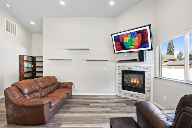 living area with a fireplace, wood finished floors, visible vents, and recessed lighting