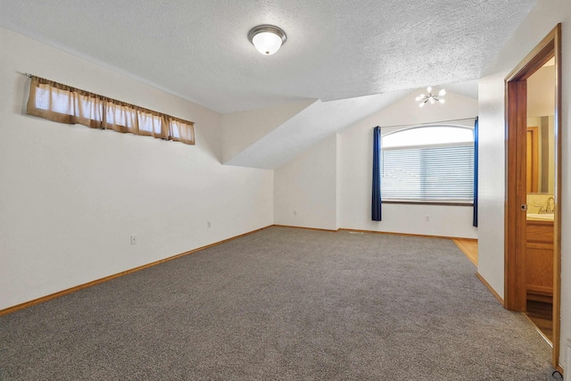 bonus room featuring a textured ceiling, a notable chandelier, lofted ceiling, and carpet floors