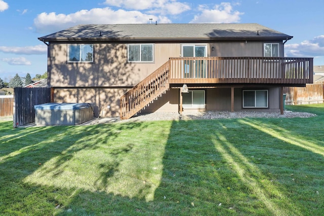 rear view of house featuring stairway, a wooden deck, fence, and a lawn