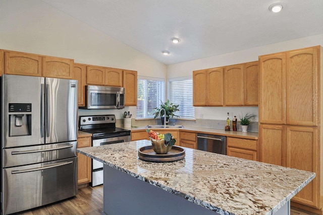 kitchen featuring a sink, appliances with stainless steel finishes, vaulted ceiling, dark wood-type flooring, and a kitchen island