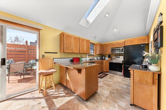 5905 W Excell Ave, Spokane, WA 99208 - kitchen featuring a peninsula, recessed lighting, a skylight, stainless steel appliances, and a breakfast bar area