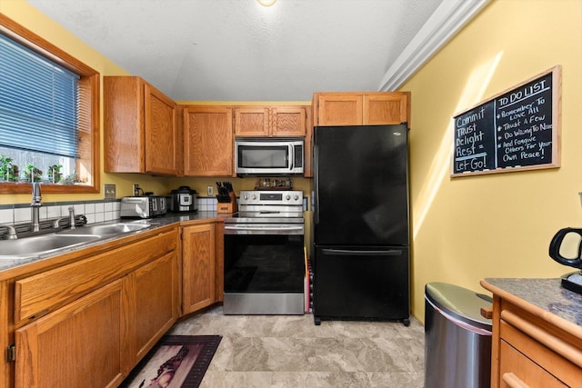 5905 W Excell Ave, Spokane, WA 99208 - kitchen featuring a sink, brown cabinetry, dark countertops, and stainless steel appliances