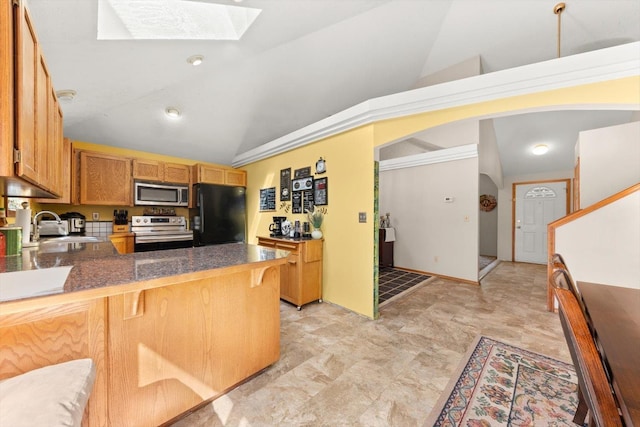 5905 W Excell Ave, Spokane, WA 99208 - kitchen with a peninsula, dark countertops, lofted ceiling with skylight, stainless steel appliances, and a sink