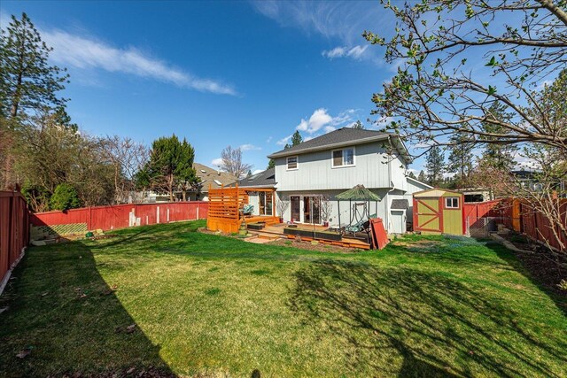 5905 W Excell Ave, Spokane, WA 99208 - back of property with french doors, a fenced backyard, a wooden deck, a yard, and a storage unit