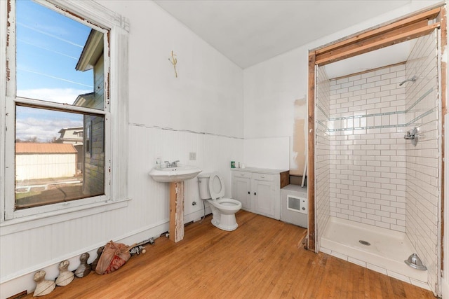 full bathroom featuring a sink, a stall shower, and wood finished floors