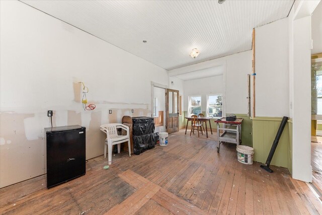 misc room with wood-type flooring and a wainscoted wall