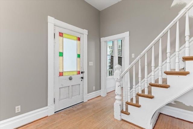 entryway with stairway, baseboards, and wood finished floors