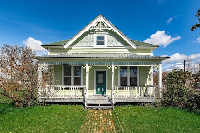 victorian house with a front lawn and covered porch