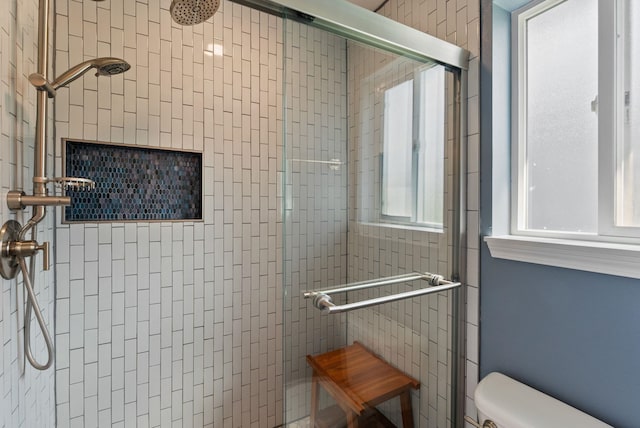 bathroom featuring a shower stall and toilet
