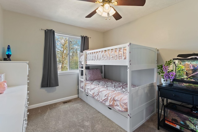 carpeted bedroom featuring visible vents, baseboards, and ceiling fan