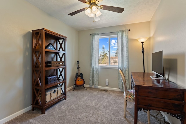 office with visible vents, ceiling fan, carpet flooring, and baseboards