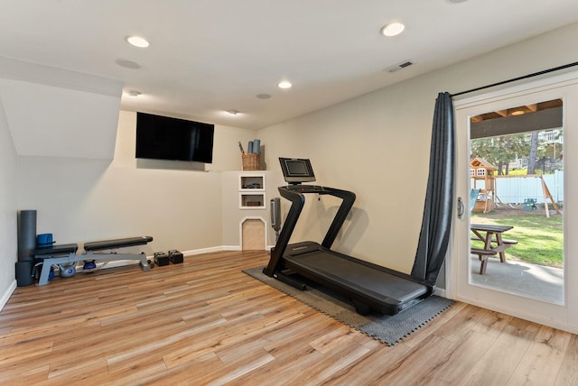 workout area with light wood-style floors, recessed lighting, visible vents, and baseboards
