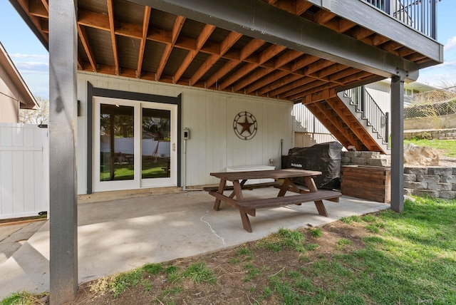 view of patio / terrace featuring fence and stairs