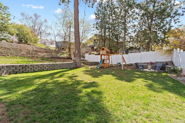 view of yard with a fenced backyard and a playground