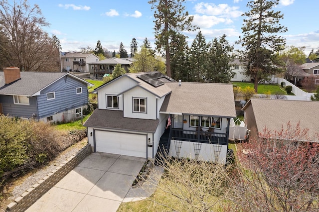 split level home with roof with shingles, a garage, a residential view, and driveway