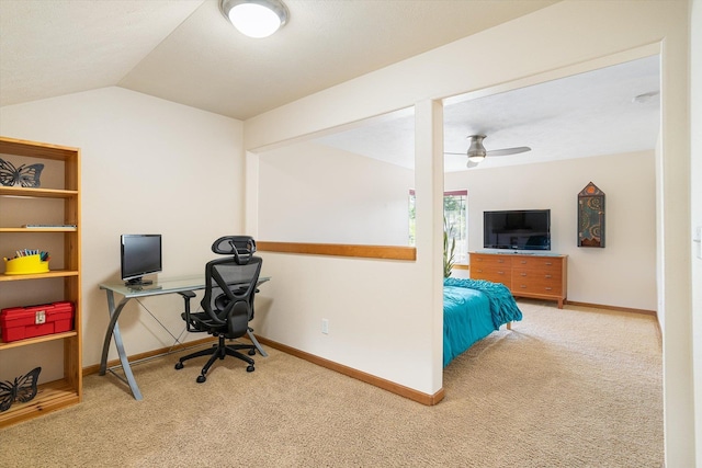carpeted office space with baseboards, ceiling fan, and vaulted ceiling