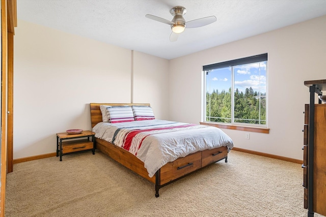 bedroom featuring baseboards, ceiling fan, and light colored carpet