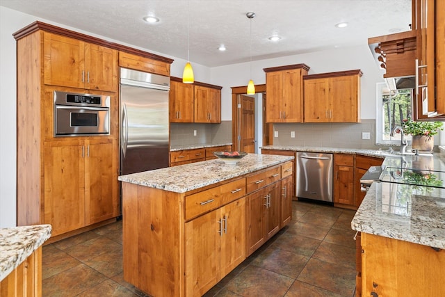 kitchen featuring tasteful backsplash, a center island, appliances with stainless steel finishes, and light stone countertops