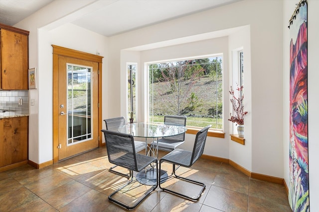 dining room featuring baseboards and tile patterned flooring