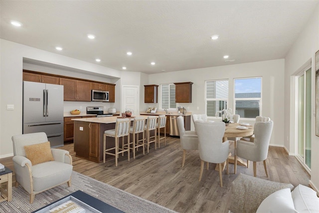 dining area with light wood-style flooring, baseboards, and recessed lighting