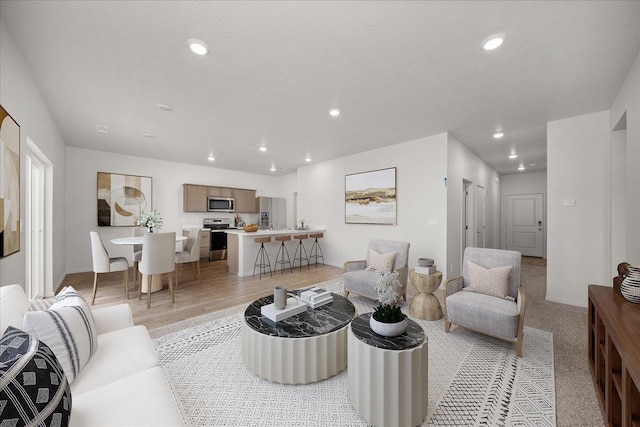 living room with light wood-type flooring, baseboards, and recessed lighting