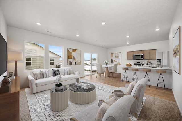 living room with recessed lighting and light wood-style floors