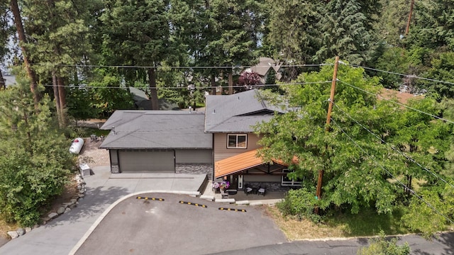 12808 N N Park St, Newman Lake, WA 99025 - rear view of house featuring stone siding, an attached garage, a patio area, a shingled roof, and driveway