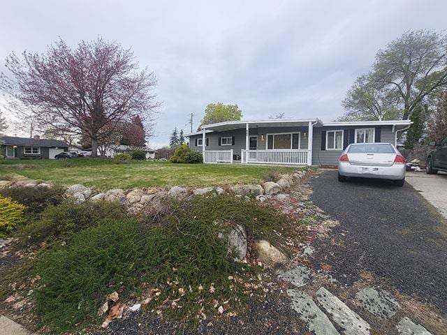 manufactured / mobile home with covered porch and a front yard