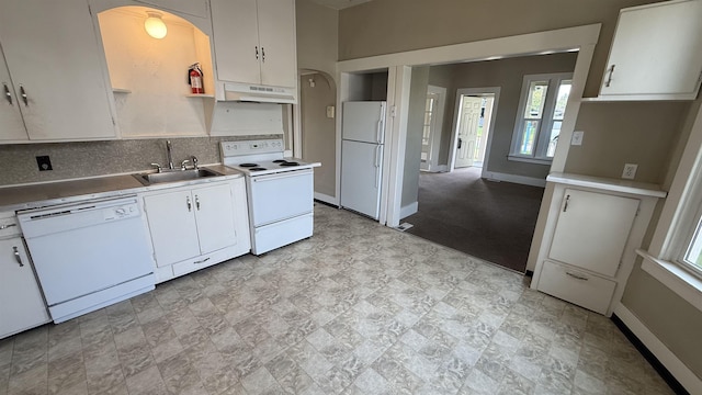 723 W Montgomery Ave, Spokane, WA 99205 - kitchen with white appliances, arched walkways, under cabinet range hood, backsplash, and white cabinets