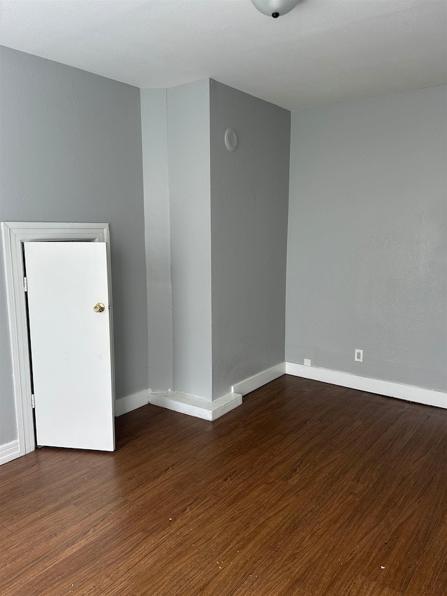 empty room with wood finished floors and baseboards