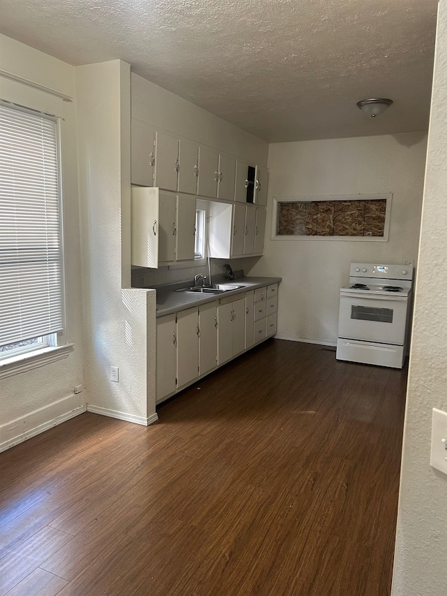 kitchen featuring dark wood-type flooring, electric stove, baseboards, and a textured ceiling