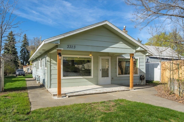 back of property with a patio area, fence, and a chimney