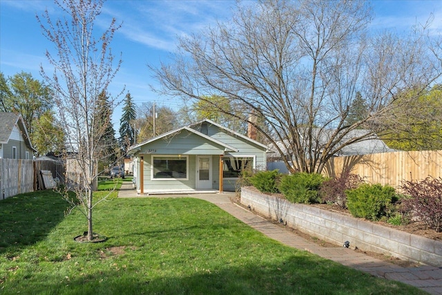 view of front facade featuring a front yard and fence