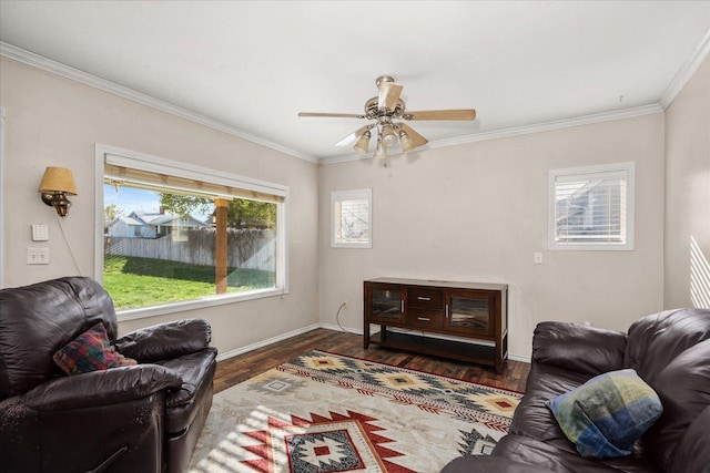 living area with crown molding, wood finished floors, ceiling fan, and baseboards