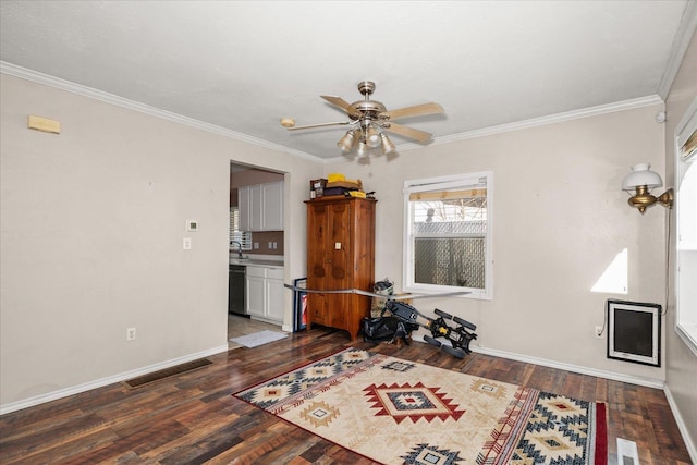 interior space with visible vents, baseboards, ceiling fan, crown molding, and wood finished floors
