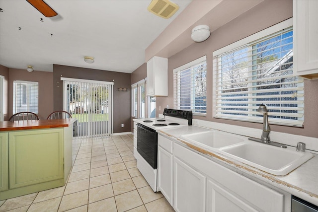 kitchen featuring light tile patterned floors, white cabinets, visible vents, white range with electric stovetop, and a sink